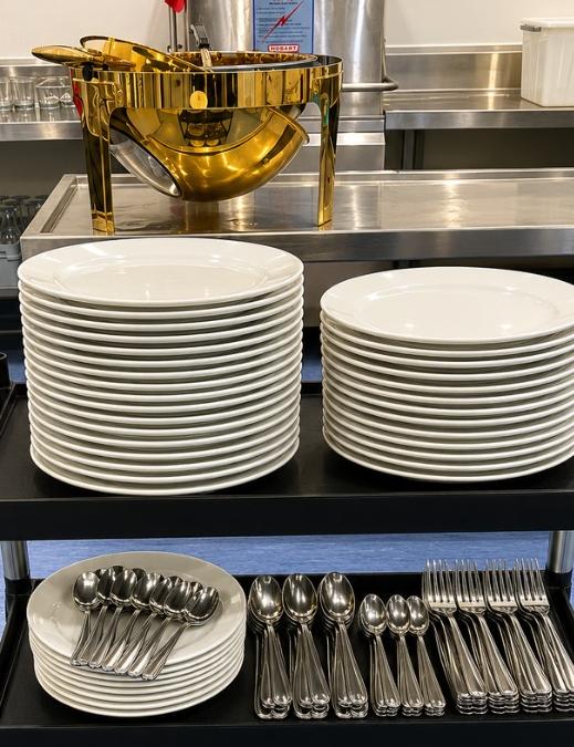 Commercial kitchen trolley stacked with spotless plates and cutlery after a Destello clean